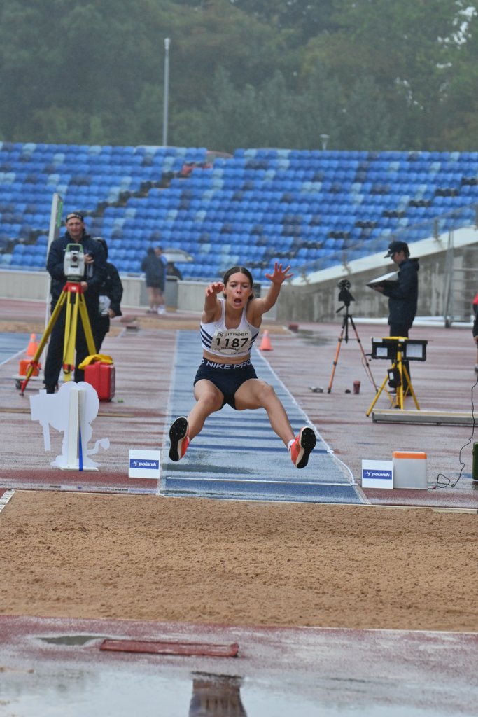 Athlete #1187 in full extension during long jump