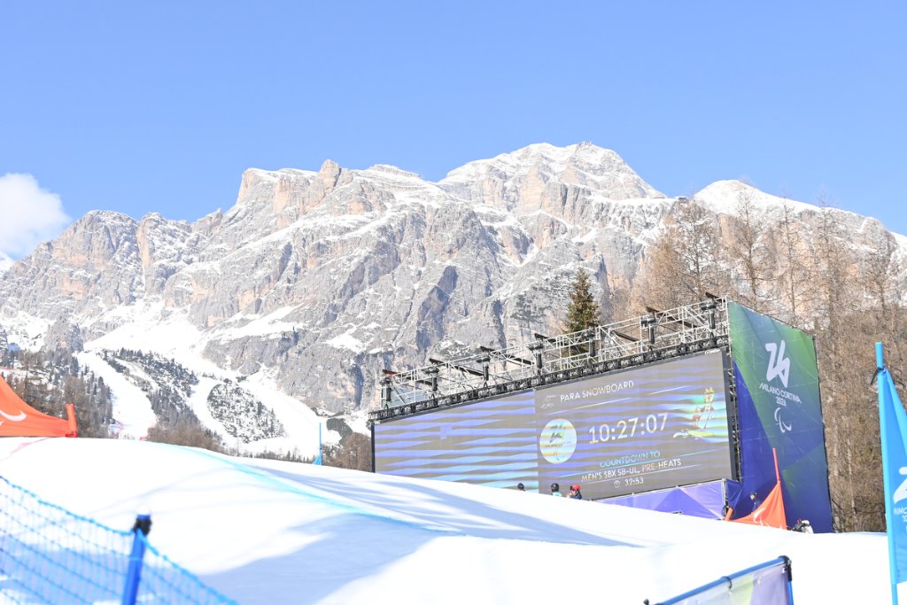 Para Snowboard scoreboard countdown with Dolomites mountains behind at Milan Cortina 2026