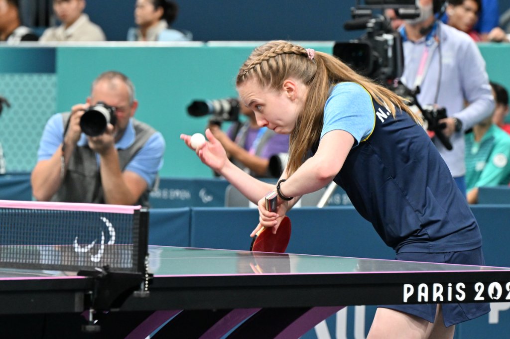 Para table tennis athlete preparing to serve at Paris 2024