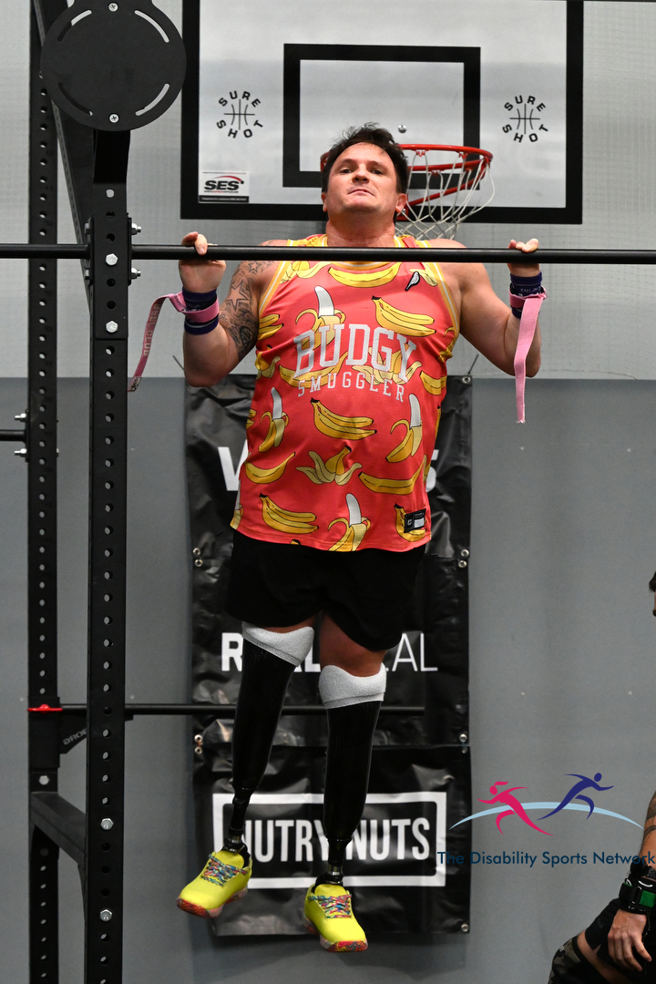 Athlete with prosthetic legs performing a pull-up on the rig at Alt Movement