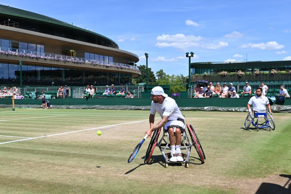 Wheelchair tennis player hitting a baseline drive at Wimbledon