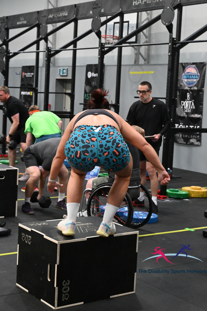 Athlete squatting on a plywood box during the Alt Movement competition