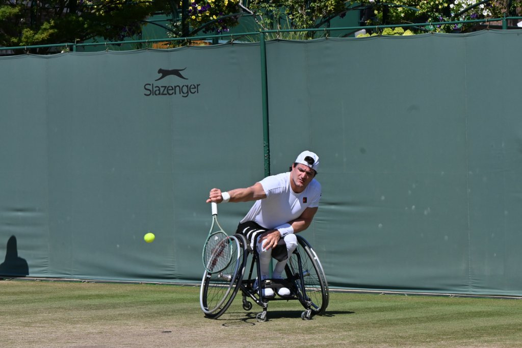 Wheelchair tennis player reaching for a backhand at Wimbledon