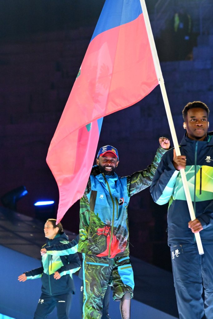 Athlete carrying national flag during parade at the 2026 Winter Paralympics Opening Ceremony