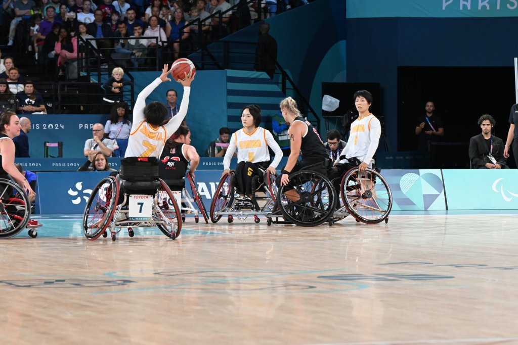 China player shooting over Canadian defenders