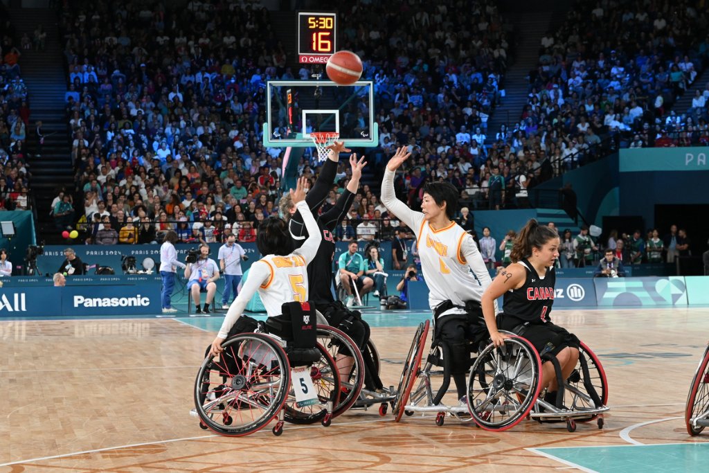 Referee tosses jump ball between Spain and France players