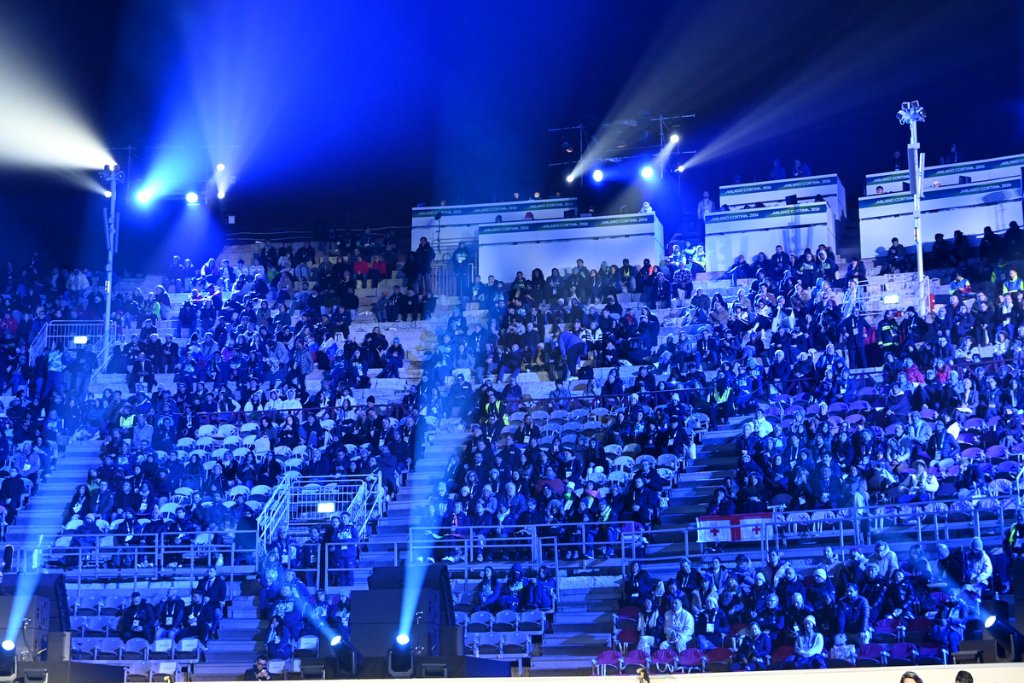Crowd in blue-lit stadium at the 2026 Winter Paralympics Opening Ceremony
