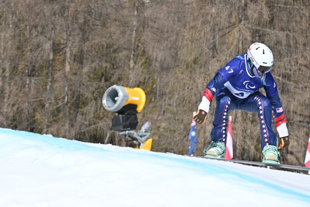 USA Para Snowboard Cross athlete in stars and stripes suit on the slope at Milan Cortina 2026