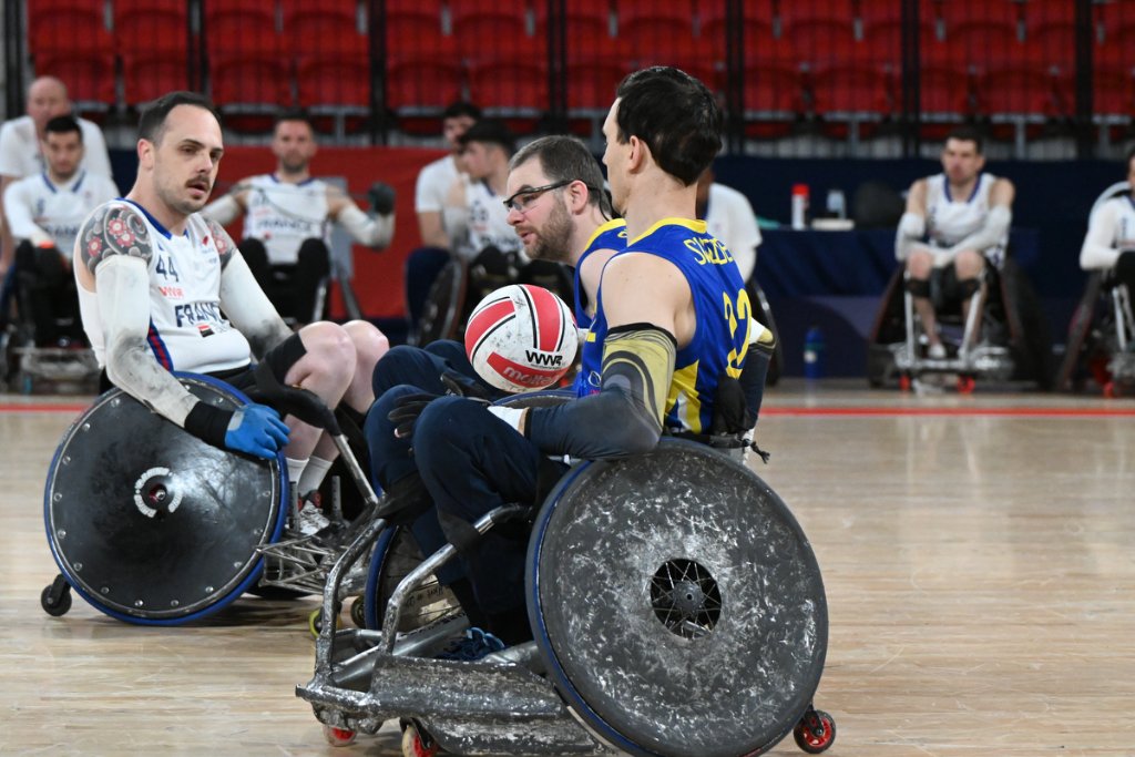 Sweden player holding ball as France defenders close in