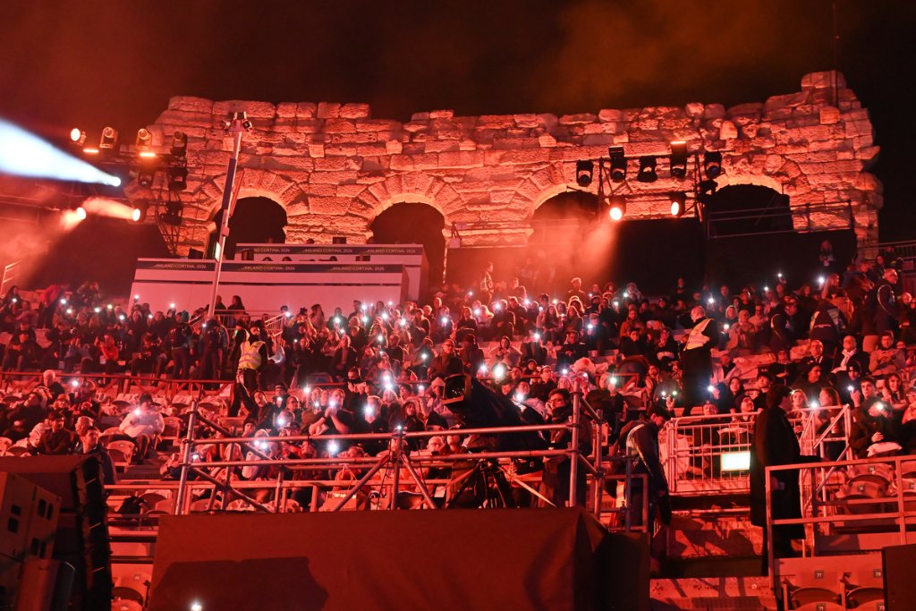 Spectators with phone lights illuminating the Verona Arena at the 2026 Winter Paralympics Opening Ceremony