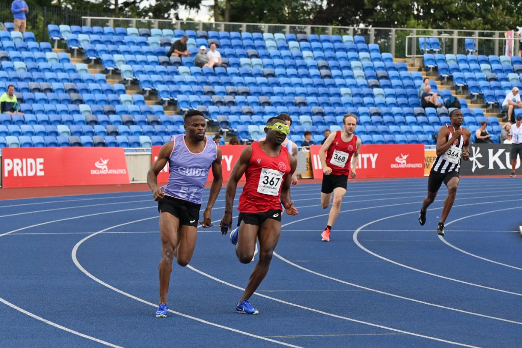 Six female sprinters launching from the start line together