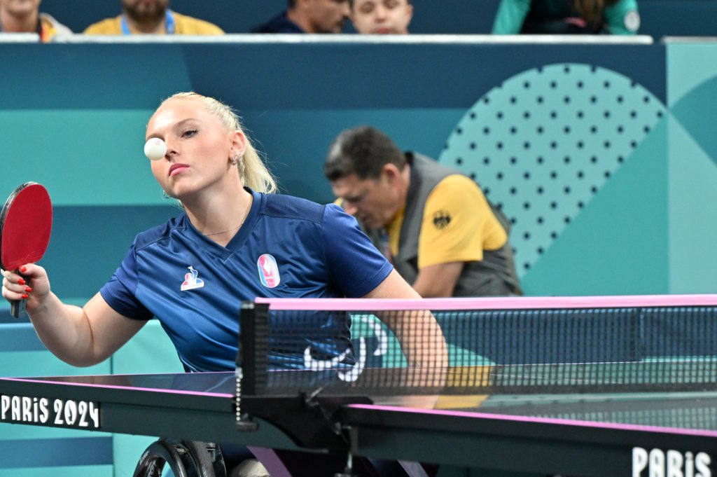 French wheelchair para table tennis player with ball close to face, Paris 2024