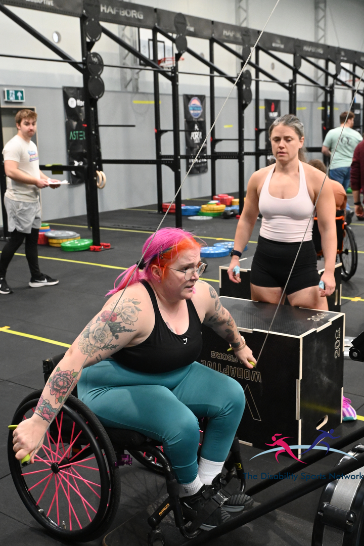 Wheelchair athlete pulling cable handles on a Concept2 machine at Alt Movement