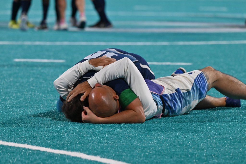 Players embrace on the ground after blind football gold medal match at Paris 2024 Paralympics