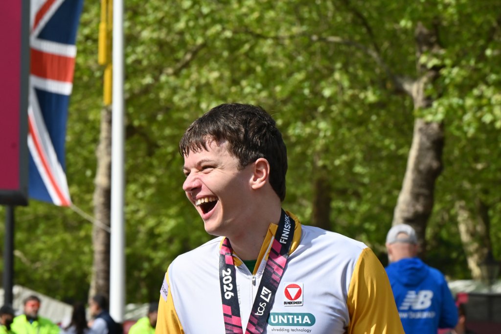 Laughing finisher with medal in front of Union Jack at London Marathon 2026