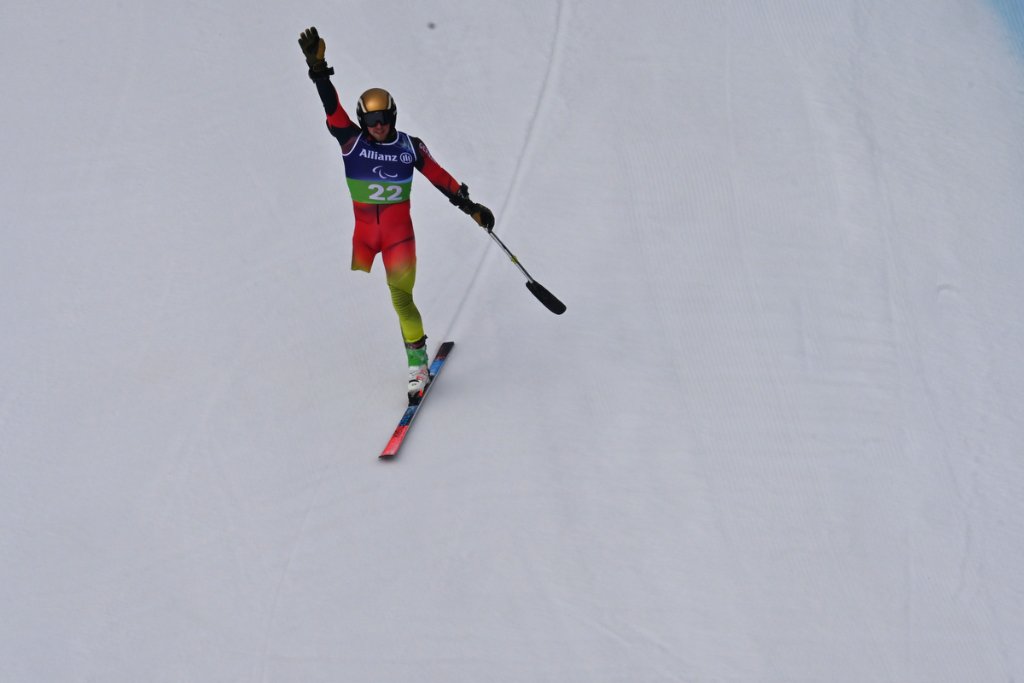 Standing para alpine skier crossing finish line at Milano Cortina 2026 Winter Paralympics