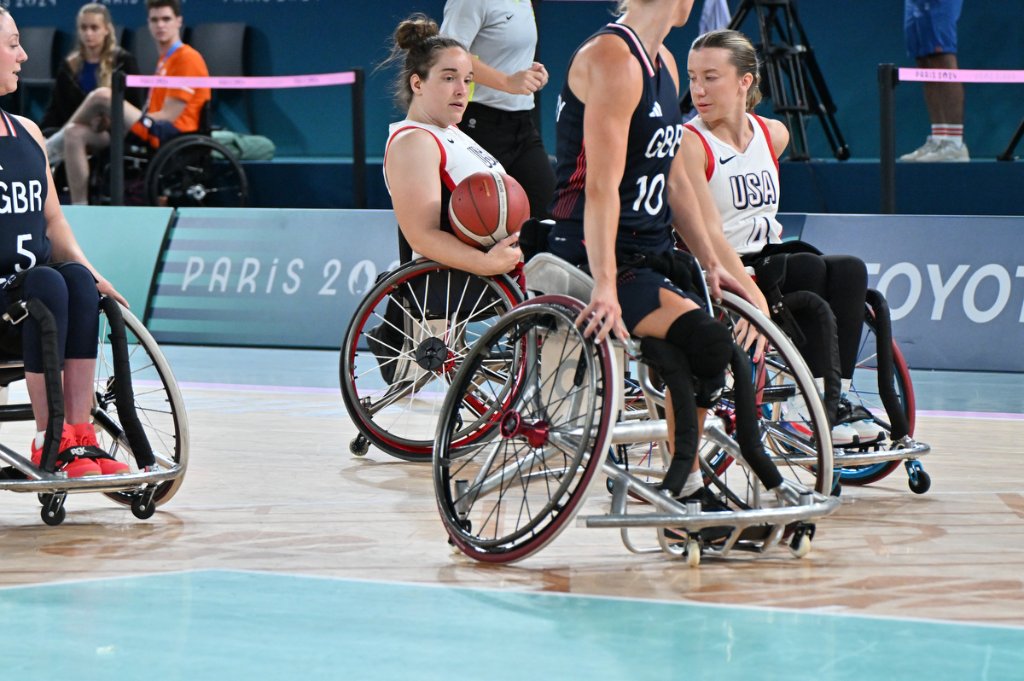 GBR player holds ball tightly against USA defender