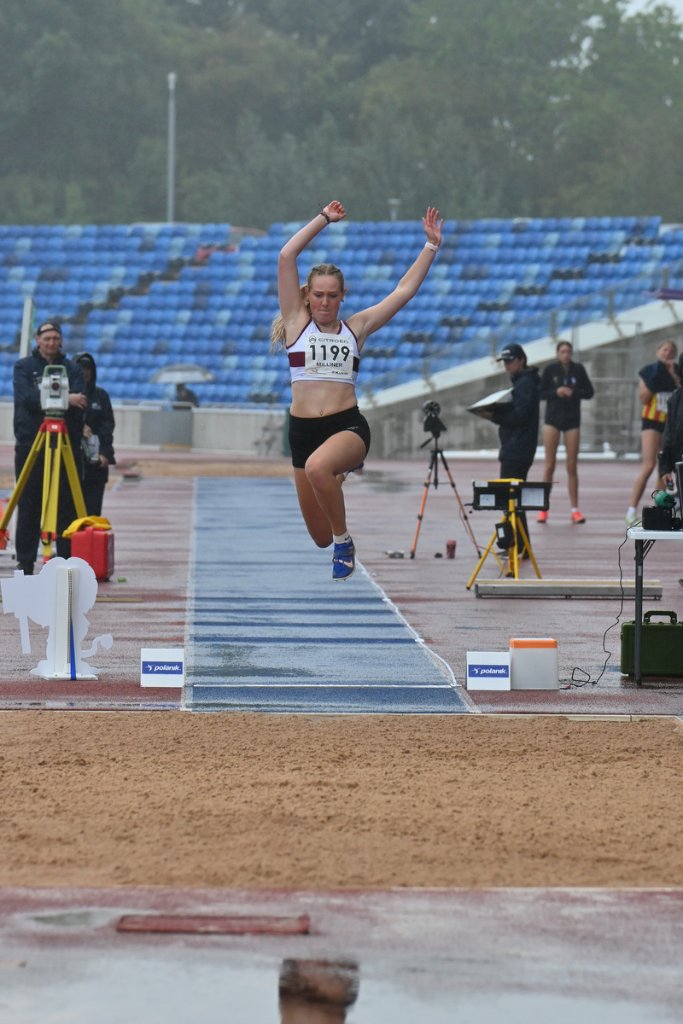 Athlete Milliner #1199 mid triple jump in the rain