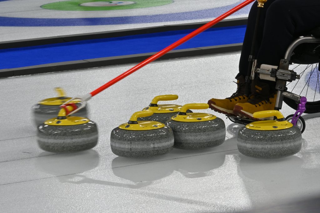 Great Britain wheelchair curling team delivering stone at Milano Cortina 2026 Winter Paralympics