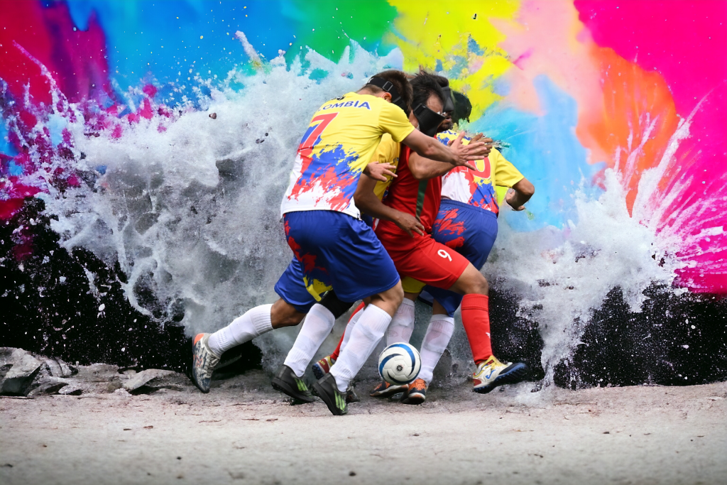 Blind football players competing for the ball with a colourful abstract background