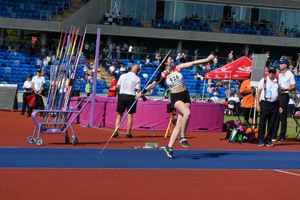 Female hurdlers clearing barriers at Birmingham Alexander Stadium