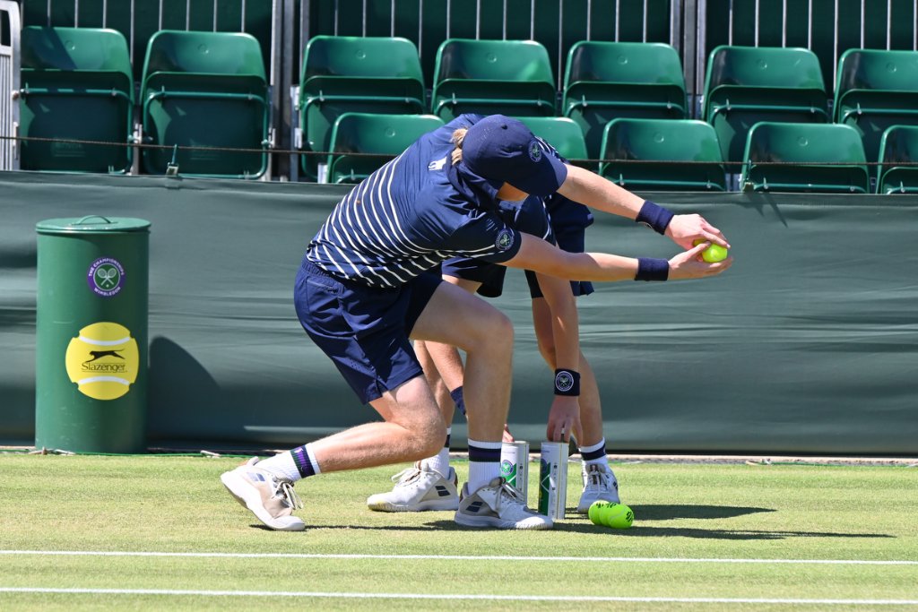 Wimbledon ball boy collecting tennis balls during wheelchair tennis match