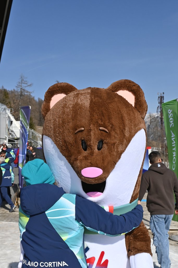 Milan Cortina 2026 mascot being hugged by a volunteer at the Winter Paralympics
