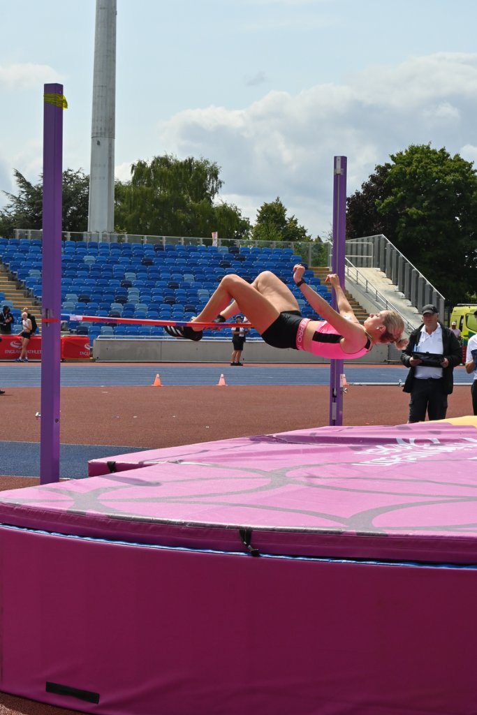Pink-clad high jumper performing Fosbury flop