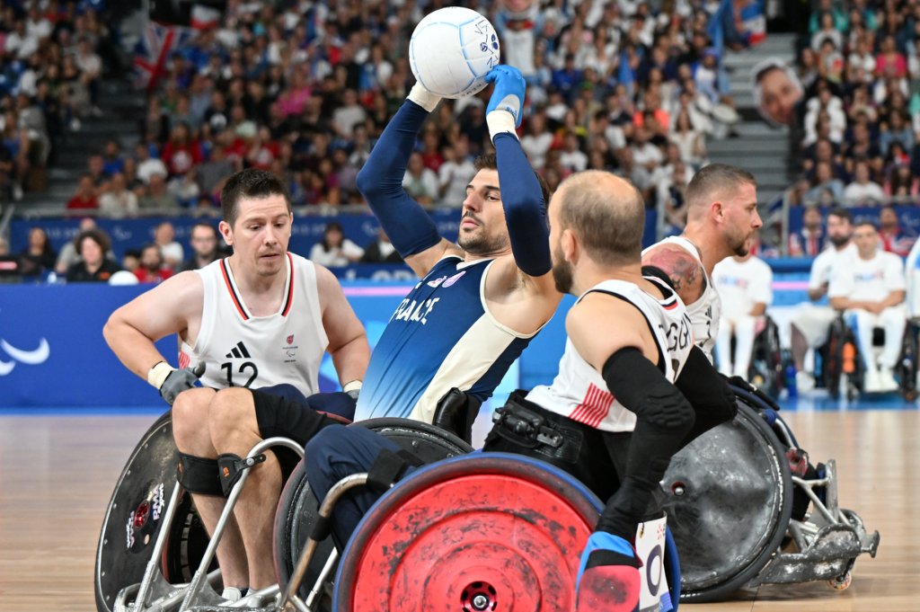 French wheelchair rugby player shoots ball over Great Britain defenders at Paris 2024 Paralympics