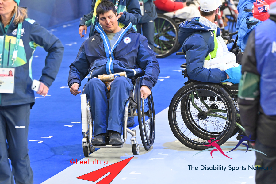 Wheelchair wheel lifting over lip at closing ceremony