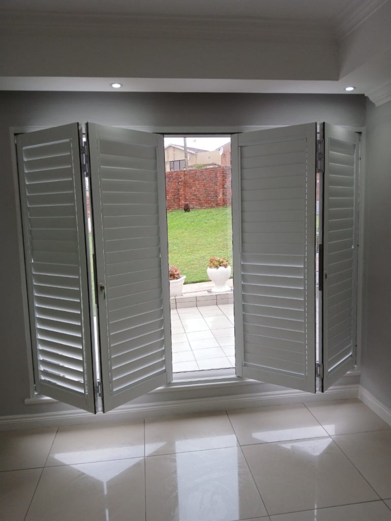 White folding security shutters opened for patio access by EasyBlinds Cape Town custom window blinds specialists