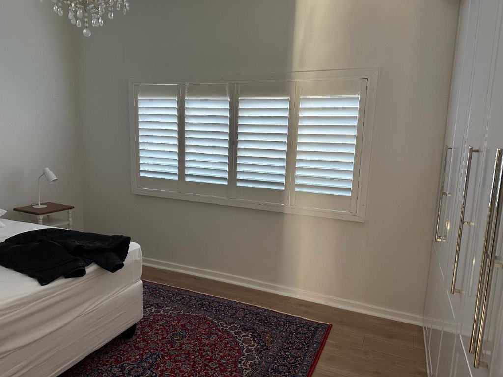 White security shutters installed in a modern bedroom by EasyBlinds Cape Town custom window blinds specialists
