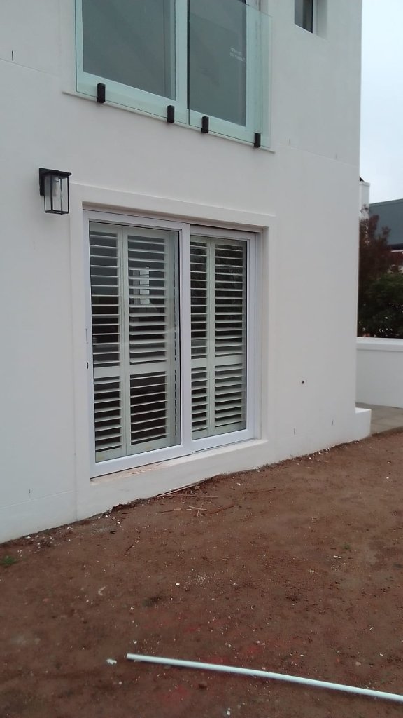 Exterior view of white security shutters on a Cape Town home by EasyBlinds Cape Town custom window blinds specialists