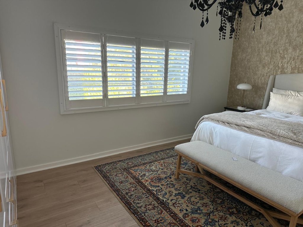Bedroom window finished with elegant white security shutters by EasyBlinds Cape Town custom window blinds specialists