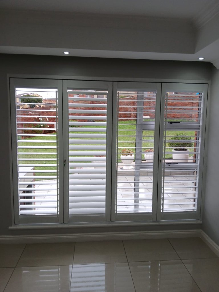 Open security shutters overlooking a residential garden by EasyBlinds Cape Town custom window blinds specialists