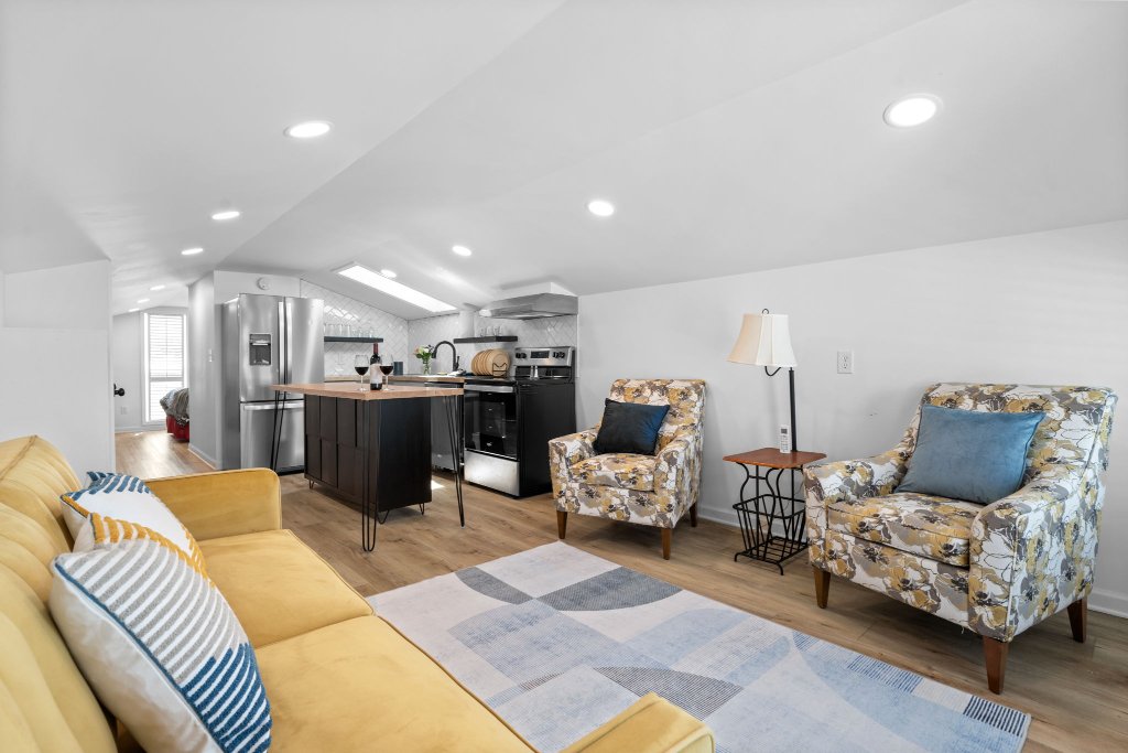 Vintner's Sky Nest full kitchen with stainless refrigerator, range, butcher block island, herringbone tile backsplash, and barn doors at Laurel Haven
