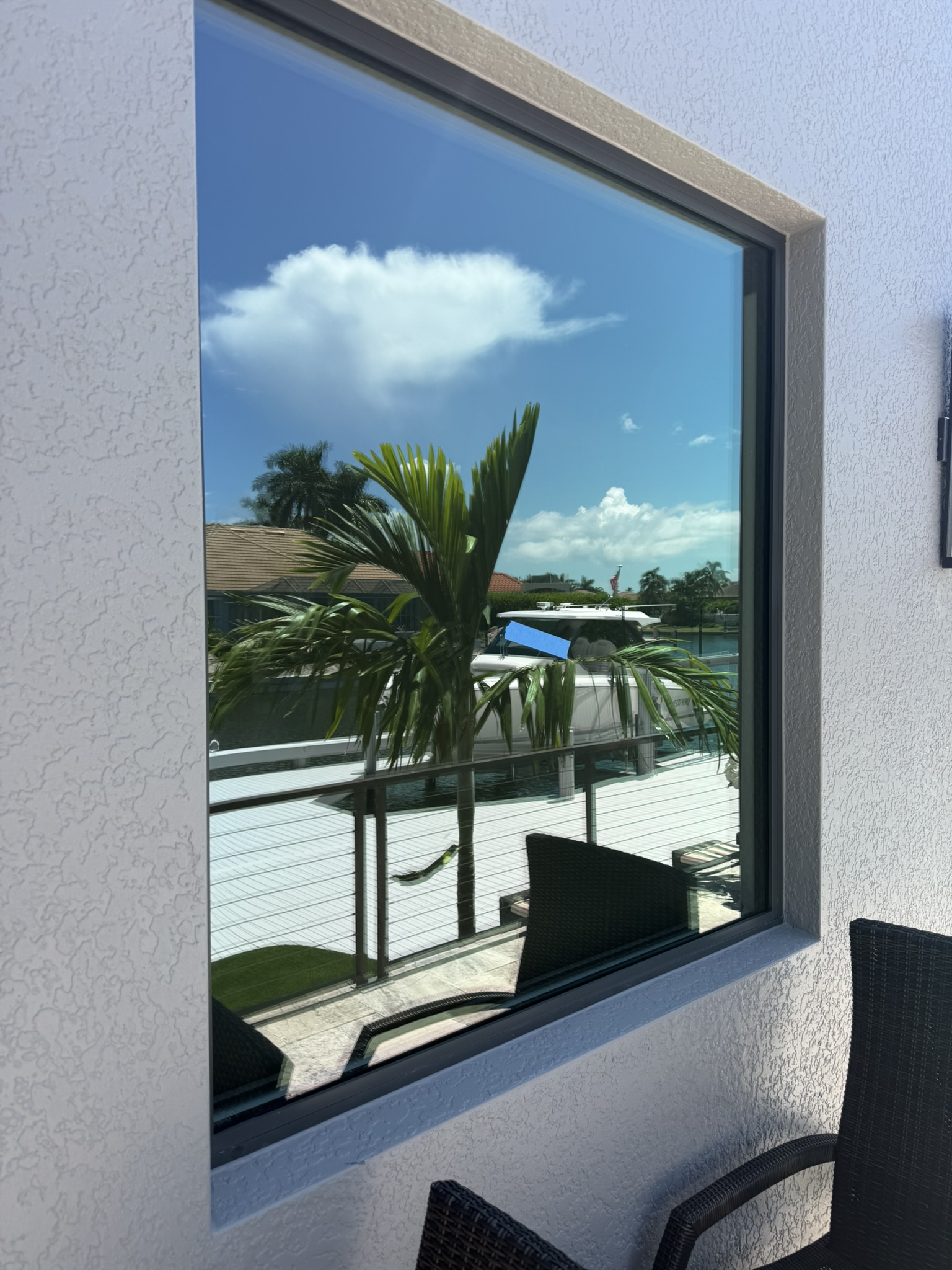 Highly reflective Low-E window on Marco Island home — the source of reflected sunlight causing turf burn below