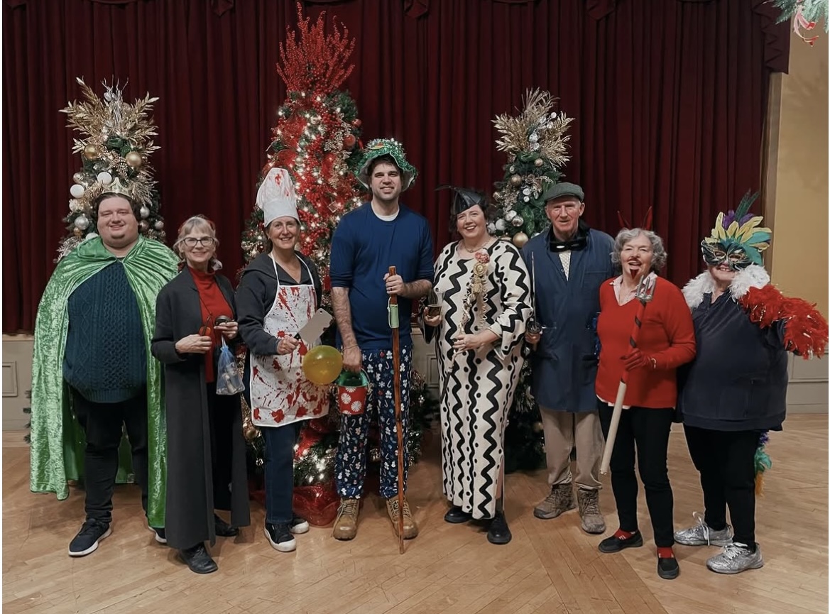 Last year’s wren day contestants lined up in costume in front of decorated Christmas trees