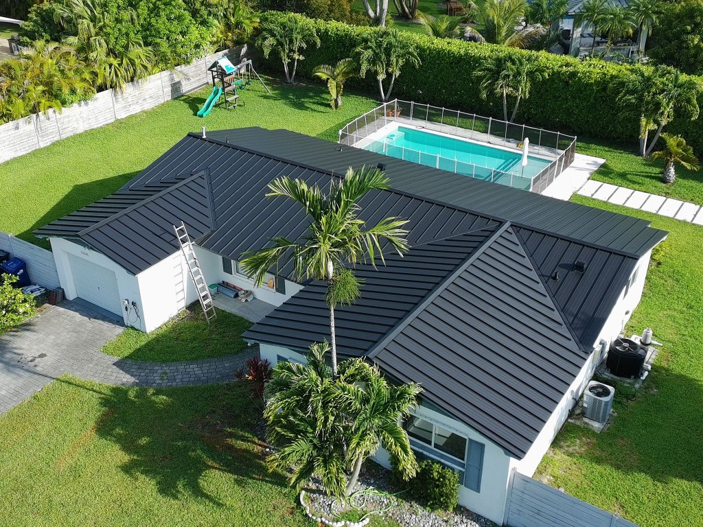 Matte black standing seam metal roof replacement completed on a South Florida home with pool