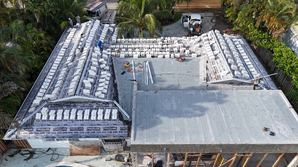 Aerial view of South Florida roof during renovation with Polyglass underlayment and stacked tile ready for installation