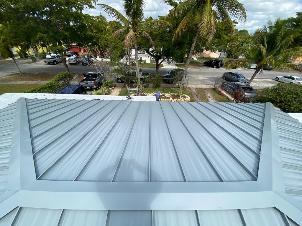 Aerial drone view of light grey standing seam metal roof installation on a South Florida home