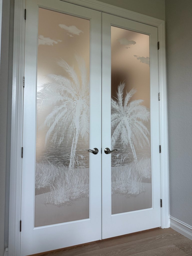 Palm artwork on white-framed double entry doors