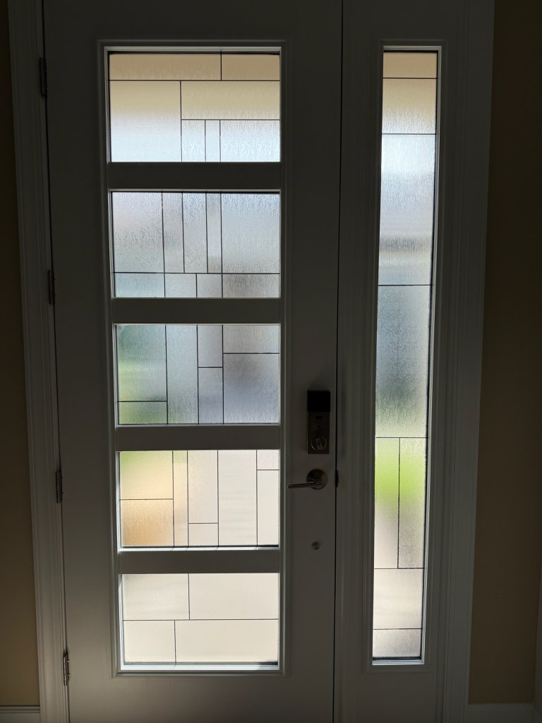 Rectangular decorative linework across divided entry-door panes