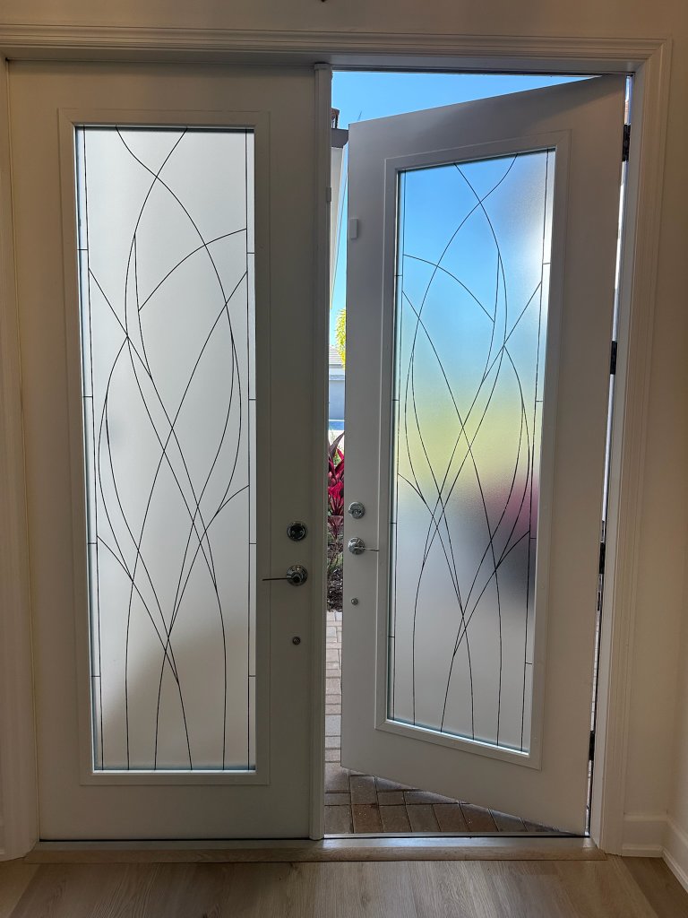 Curved frost and clear lines on an open entry door