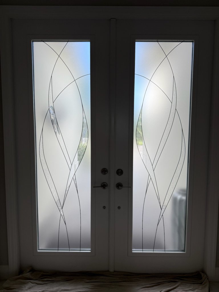 Curved clear linework on dark-framed double entry doors