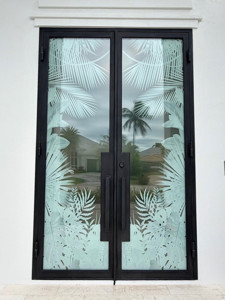 Palm foliage on black-framed double entry doors