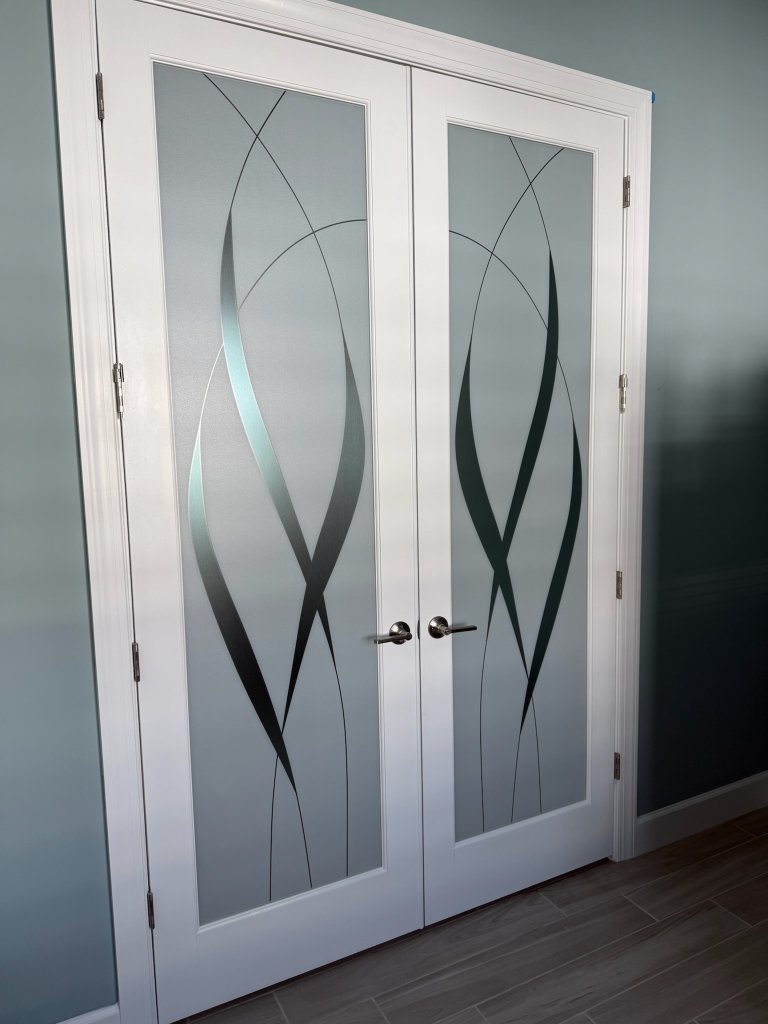 Sweeping dark accents on white-framed double entry doors