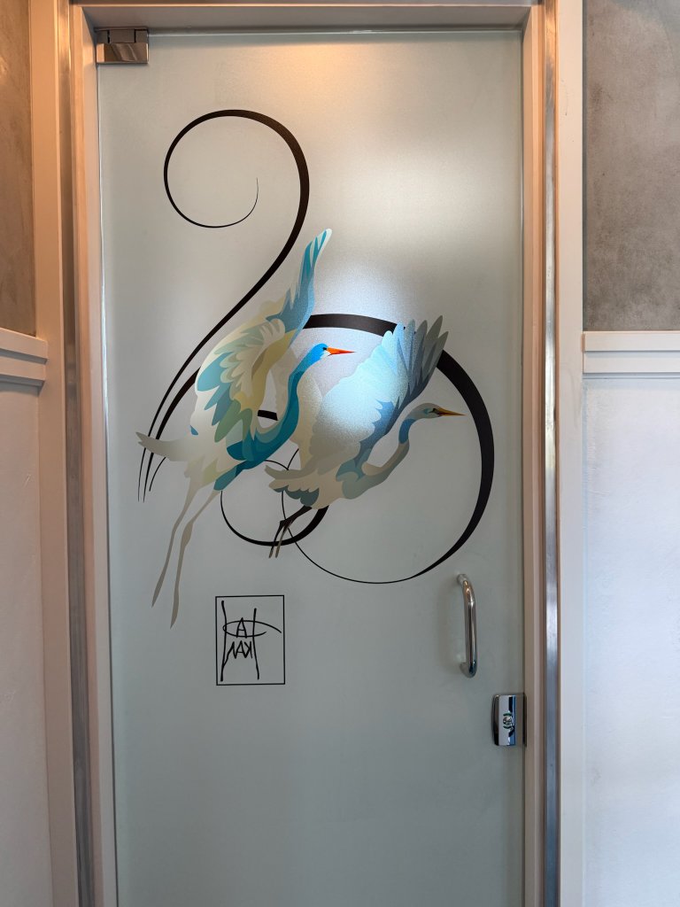 Blue accent and swirling linework on an interior glass door