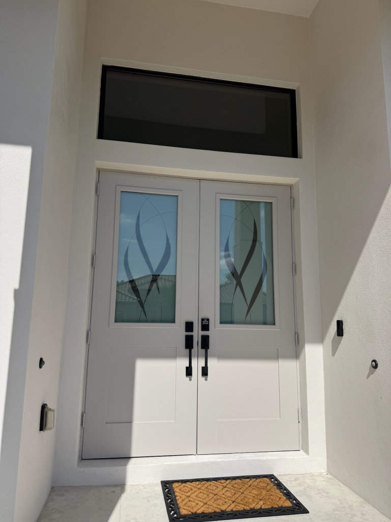 Sweeping dark accents on entry doors and sidelights
