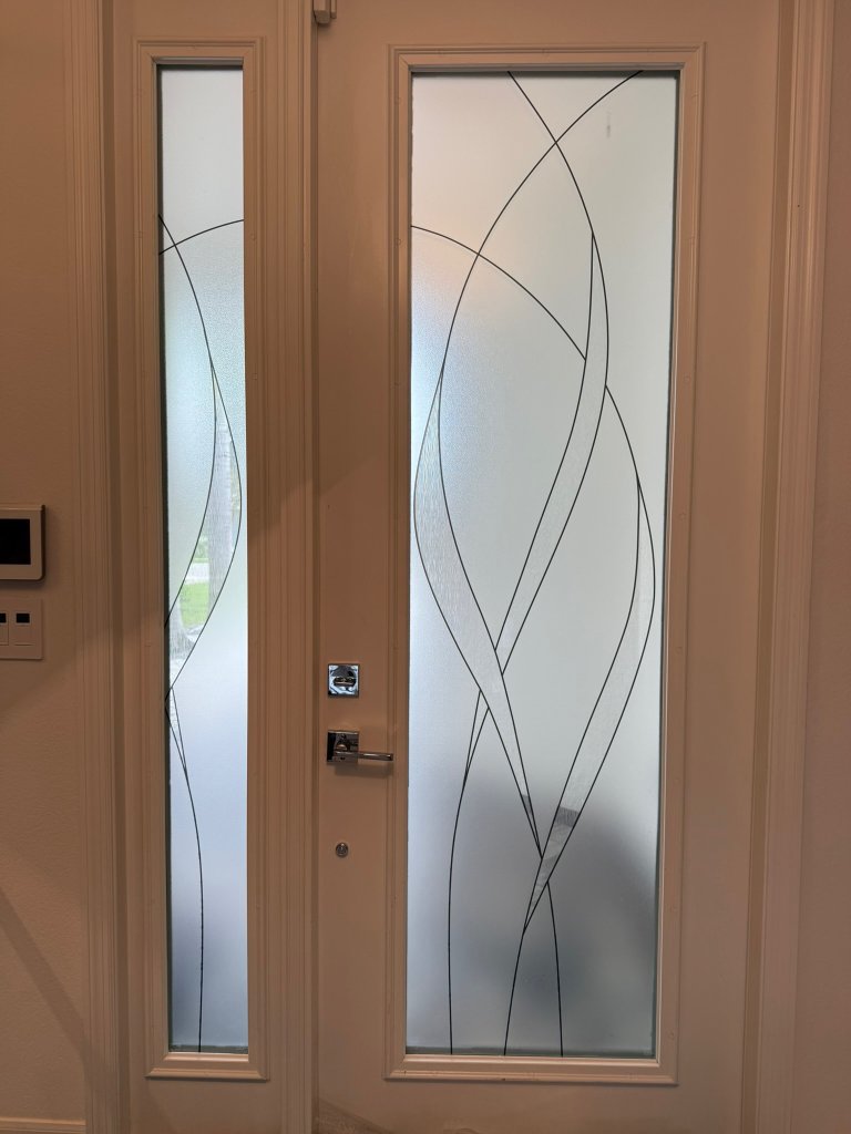Fine sweeping lines on a wood-framed entry door and sidelight